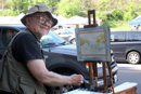 Picture of local artist Jack Dyer painting a picture of the Occoquan Farmer's Market